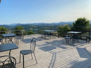 オッツァーノ・デッレミーリアにあるLa Palazzina di Ciagnanoの山を背景にテーブルと椅子の集団