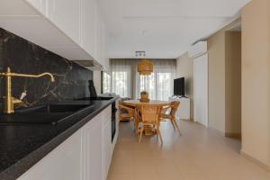 una cucina con piano di lavoro nero e tavolo di Benidorm Poniente apartment on the beach for 6 a Benidorm