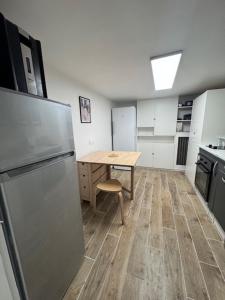 eine kleine Küche mit einem Tisch und einem Kühlschrank in der Unterkunft Welcome Home à 5 Min de Paris en RER in Vitry-sur-Seine