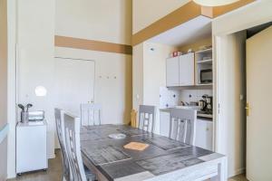 cocina con mesa y sillas en una habitación en Résidence Port Guillaume - maeva Home - 3 Pièces 6 Personnes Confort 51, en Dives-sur-Mer