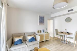 a living room with a couch and a table at OVELIA Clermont-Ferrand - Le Puy des Olivines in Clermont-Ferrand