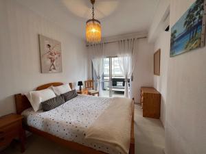 a bedroom with a bed and a room with a window at 2 Bedroom apartment in Caparica by the beach in Costa da Caparica