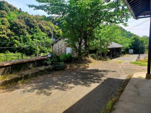 an empty road next to a building with a tree at Guesthouse Tao in Tanabe