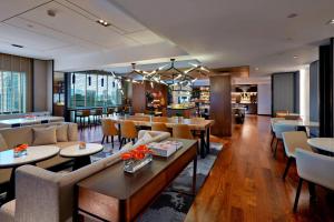 a hotel lobby with tables and chairs and a restaurant at Renaissance Kuala Lumpur Hotel & Convention Centre in Kuala Lumpur
