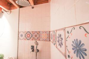 een badkamer met tegels aan de muur en een douche bij Macário Cosy Loft in Porto