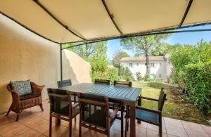 a table and chairs on a patio with a view of a yard at Les Maisons de Pont Royal en Provence - maeva Home - Maison 3 pièces 6 personnes - Sélection MAE-1676 in Mallemort