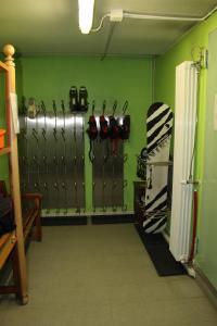 a room with a green wall with ski equipment at Il Fraitevino hotel bed & breakfast in Sestriere