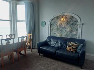 a living room with a black couch and a table at Brigg View Holiday Apartment in Filey