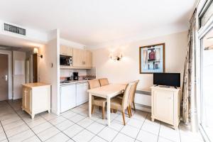 een keuken en eetkamer met een tafel en stoelen bij Résidence Héliotel Marine - maeva Home - Studio 4 Personnes Confort 78 in Cros-de-Cagnes
