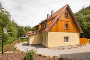 een oranje en wit huis met een oprit bij Ferienhäuser Ilsestein Doppelhaus, 100 qm, 3 Schlafzimmer in Ilsenburg