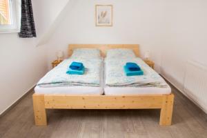 een houten bed met blauwe slippers erop bij Ferienhäuser Ilsestein Doppelhaus, 100 qm, 3 Schlafzimmer in Ilsenburg