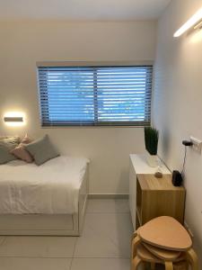 a bedroom with a bed and a desk and a window at דירת נופש משפחתית סי סייד אילת in Eilat