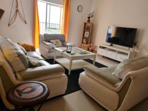 a living room with couches and a tv at Remarkable 3-Bed Apartment in Kilamba - Luanda in Luanda