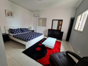 a living room with a bed and a red rug at Remarkable 3-Bed Apartment in Kilamba - Luanda in Luanda