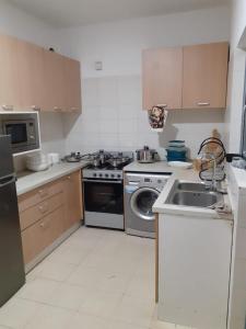 a kitchen with a stove and a sink and a dishwasher at Remarkable 3-Bed Apartment in Kilamba - Luanda in Luanda