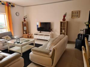 a living room with couches and a flat screen tv at Remarkable 3-Bed Apartment in Kilamba - Luanda in Luanda