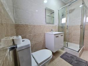 uma casa de banho com um WC, um chuveiro e um lavatório. em Lovely 5-Bed Suits - Guest House in Luanda em Luanda