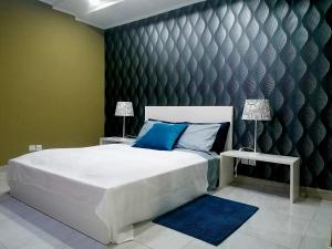 um quarto com uma grande cama branca com almofadas azuis em Lovely 5-Bed Suits - Guest House in Luanda em Luanda