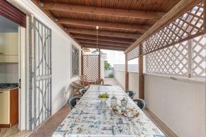 ein Esszimmer mit einem langen Tisch auf dem Balkon in der Unterkunft Enjoy holiday By Vivimy in Ugento