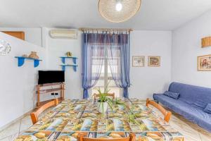 ein Wohnzimmer mit einem Tisch und einem blauen Sofa in der Unterkunft Enjoy holiday By Vivimy in Ugento