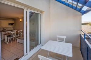ein Balkon mit einer weißen Bank und einem Tisch in der Unterkunft Résidence Bleu Marine - maeva Home - 2 Pièces 4 Personnes Confort MAE-2045 in Lacanau + 9 Fotos