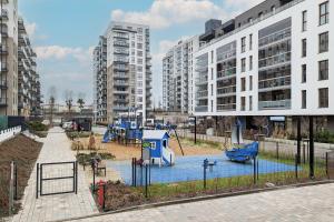 a playground in the middle of a city with tall buildings at Zajezdnia Wrzeszcz Modern Apartment with Balcony & Parking Gdańsk by Renters in Gdańsk