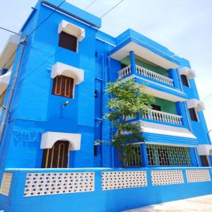 un edificio blu con un albero di fronte di Goroomgo J K Inn Puri Sea View Room a Puri