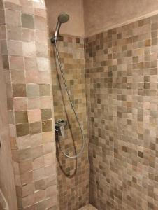 La salle de bains est pourvue d'une douche avec un pommeau de douche. dans l'établissement Les Jardins de l'Atlas, à Marrakech