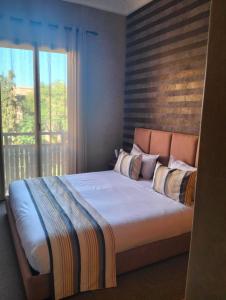 una camera da letto con un grande letto e una finestra di Les Jardins de l'Atlas a Marrakech