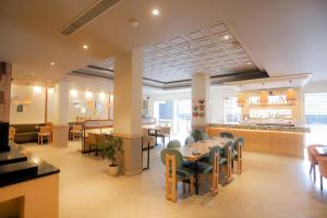Un restaurante con una mesa y sillas y un bar. en Park Inn by Radisson,South Delhi, en Nueva Delhi