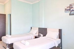 Postel nebo postele na pokoji v ubytování Homestay Dalimo 2 Syariah Payakumbuh RedPartner