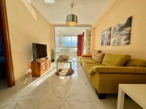 een woonkamer met een bank en een televisie bij Apolo XI Calpe vistas al mar in Calpe