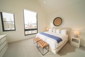 a white bedroom with a large bed and two windows at Wolf Rock Home 82 in Keystone
