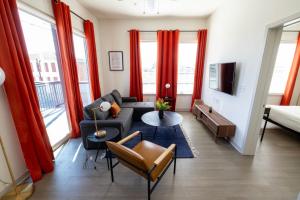 - un salon avec des rideaux rouges et un canapé dans l'établissement Modern Nulu 2BR CozySuites 04, à Louisville