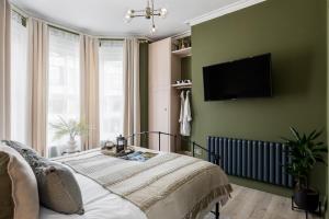 a bedroom with a bed and a flat screen tv at Stylish Central Apartment in Bournemouth