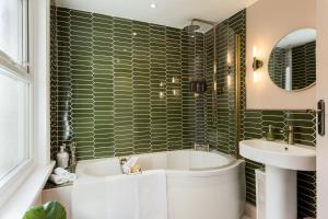 a bathroom with a tub and a sink at Stylish Central Apartment in Bournemouth