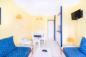 een woonkamer met twee blauwe stoelen en een tafel bij Résidence Port Bourgenay - maeva Home - 2 Pièces 5 Personnes Confort 10 in Talmont