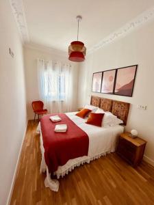 a bedroom with a large bed with a red blanket at Los Magnolios de Laín Calvo in Burgos