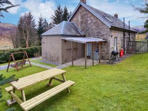 a picnic bench in front of a building at Station Cottage in Trinafour