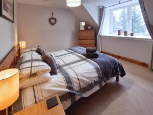 a bedroom with a bed and a window at Station Cottage in Trinafour