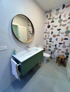 a bathroom with a sink and a mirror and a toilet at Los Magnolios de Laín Calvo in Burgos