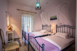 two beds in a room with pink walls at Villa Iliaktida - Private Villa with large Pool, Garden, Outdoor Kitchen & BBQ in Lithakia