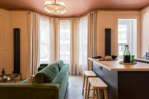een woonkamer met een groene bank en een tafel bij Stylish Central Apartment in Bournemouth