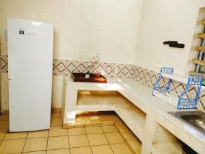 a kitchen with a sink and a bench in a room at Upani in Diani in Diani Beach