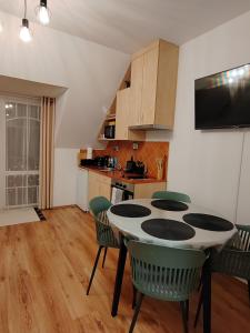 una cucina e una sala da pranzo con tavolo e sedie di Orsika HillTop Apartman a Eger