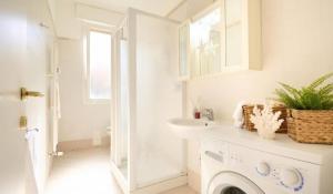 a white bathroom with a sink and a washing machine at HomeSerra 2 in Bologna
