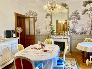 a dining room with a table and a mirror at La Villa des Roses Gîte Chambres d'hôtes Piscine chauffée in Luçon