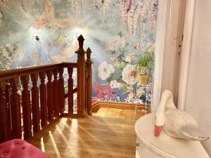 Habitación con escalera y papel pintado con motivos florales en La Villa des Roses Gîte Chambres d'hôtes Piscine chauffée, en Luçon