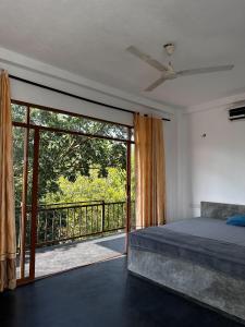 Un dormitorio con una cama y una gran puerta corrediza de vidrio. en Karu's place, en Hikkaduwa
