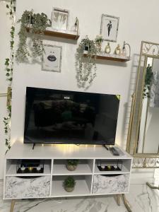 a living room with a flat screen tv on a white entertainment center at Orphea - Charming Studio Villeparisis - Proche gare / CDG / Parc des expositions in Villeparisis